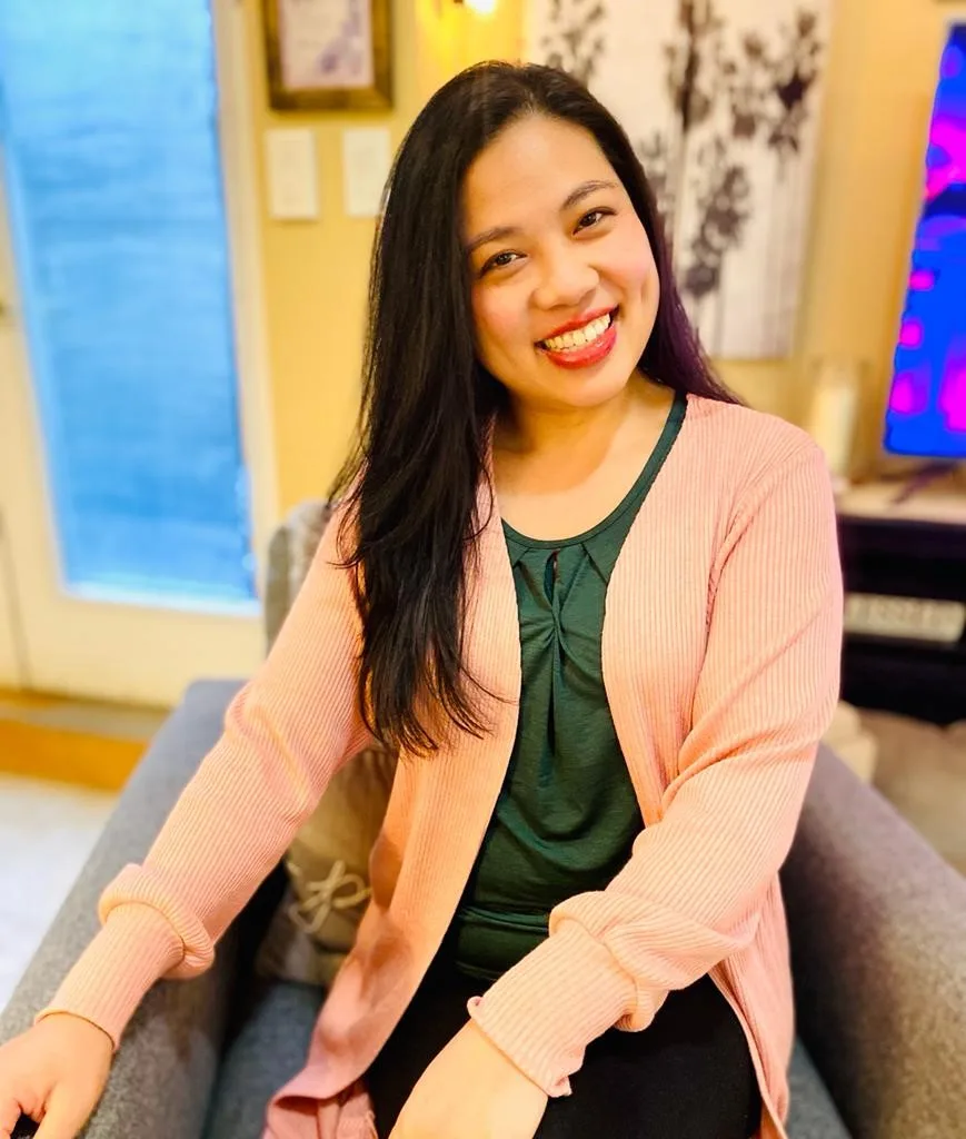 Janice Ocampo smiling, seated in a calm indoor space.